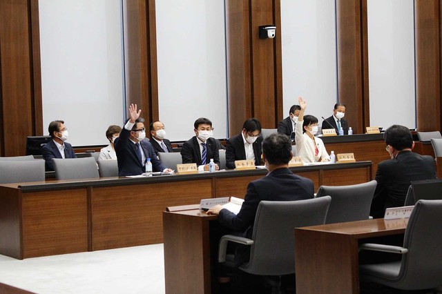 県民投票条例案に賛成して挙手する江尻かな議員と中村はやと議員